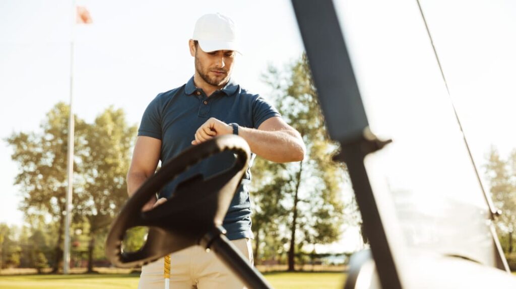 Golfer prüft Golfuhr am Handgelenk auf dem Golfplatz